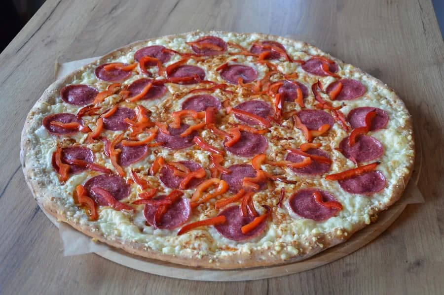 Pizza Paola: salami i świeża papryka na cienkim, wyrabianym cieście